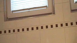 MILF with big tits is pissing in the bathroom