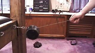 Redheaded mistress pulls weights attached to bondaged dude