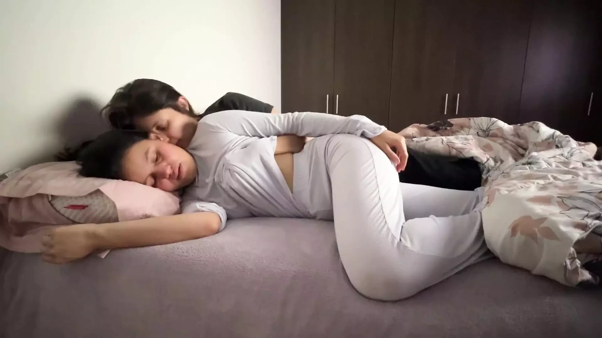 Lesbians snuggle in bed and touch their asses